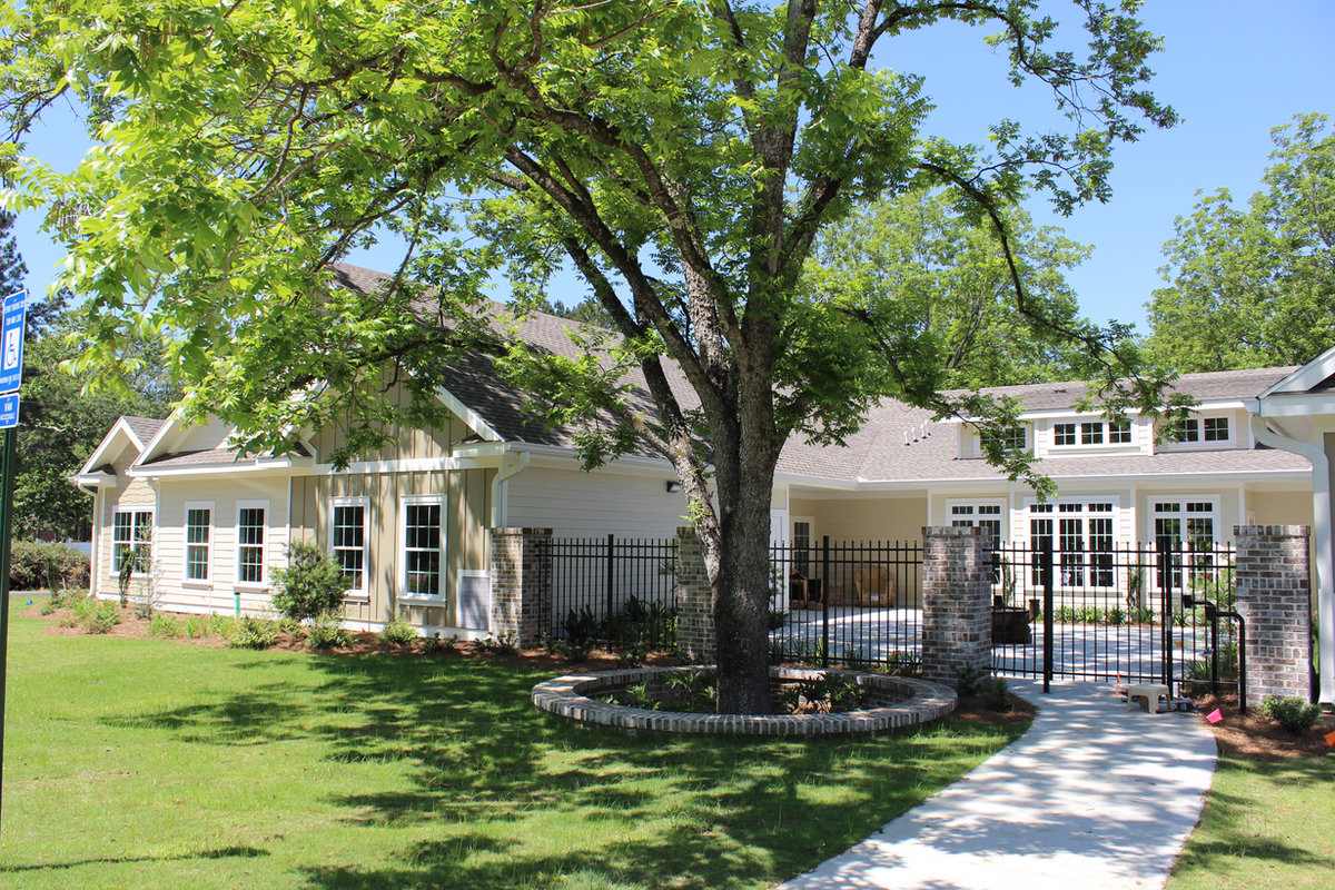 Residential assisted living home with covered porch and mature pecan tree at The Orchard at Stone Creek, Hahira GA