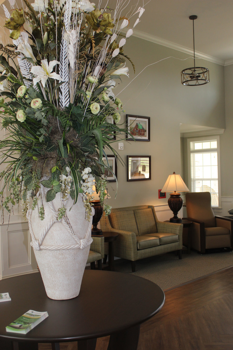 Comfortable sitting lounge with armchairs and a fresh floral arrangement at The Orchard at Stone Creek, Hahira GA